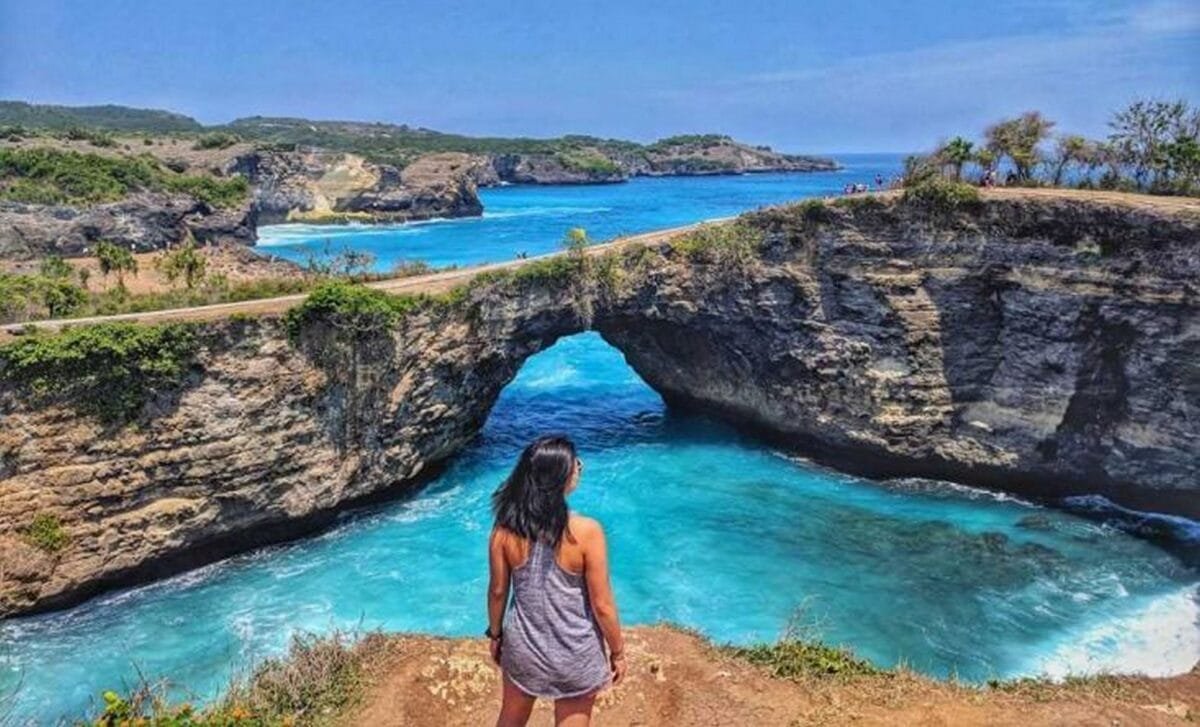 Aerial view of Kelingking Beach in Nusa Penida with turquoise waters and rugged cliffs.